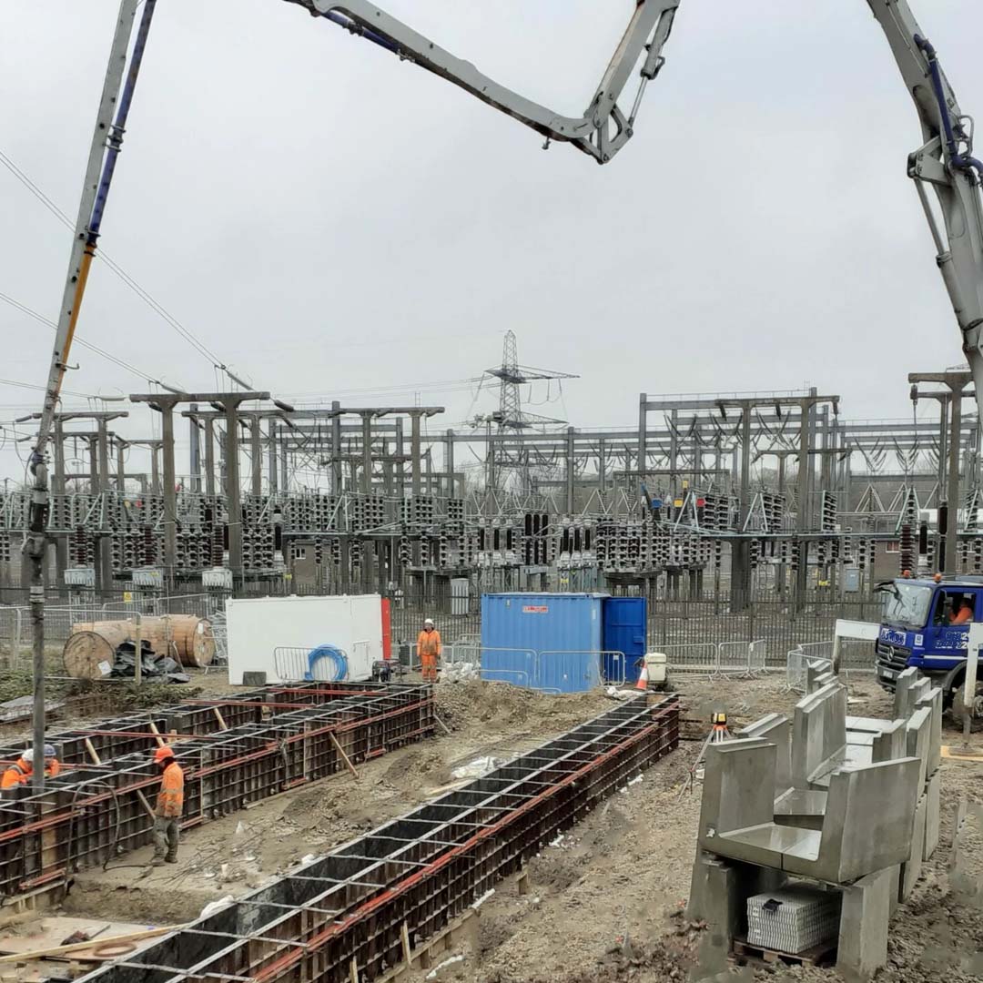 Construction site at an electrical substation featuring concrete foundation formwork and heavy machinery in progress.